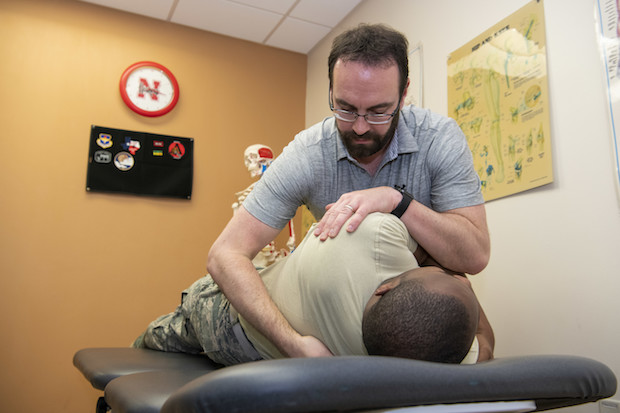 a physical therapist moving a man