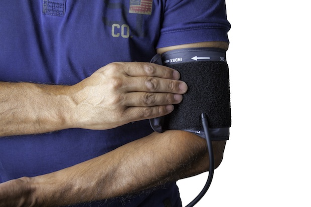 A hand placing a cuff around the arm in order to test blood pressure