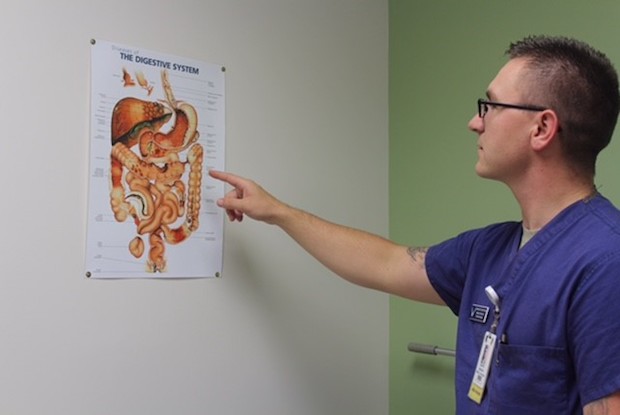 a man pointing at a diagram of intestines