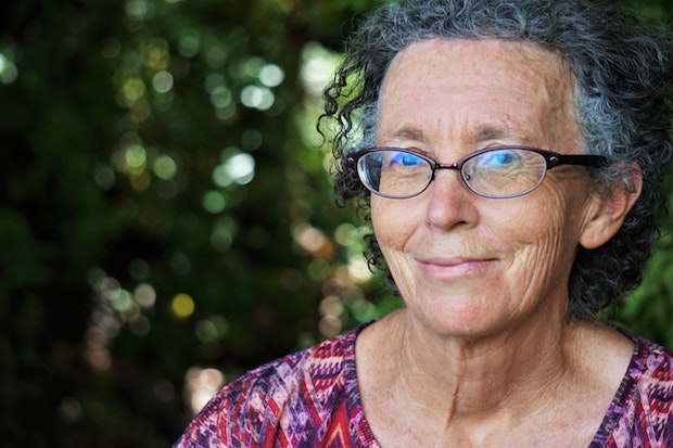 an older woman with curly hair and glasses