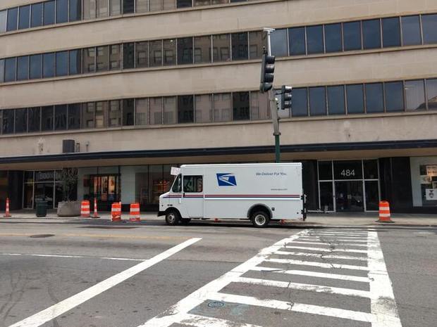 USPS van parked outside of a building