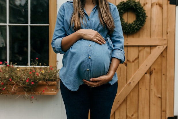 a pregnant woman holding her stomach